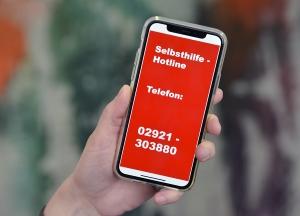 Foto von einem Handy mit der Telefonnummer der Hotline